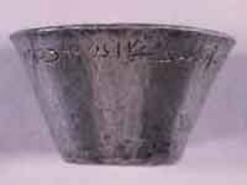 Small silver cup after conservation treatment, showing a row of Demotic script circling the upper edge.